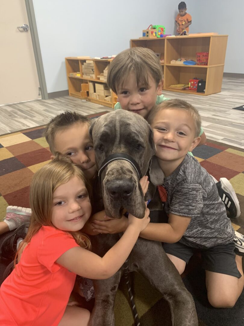 A group of kids with a dog in the middle.