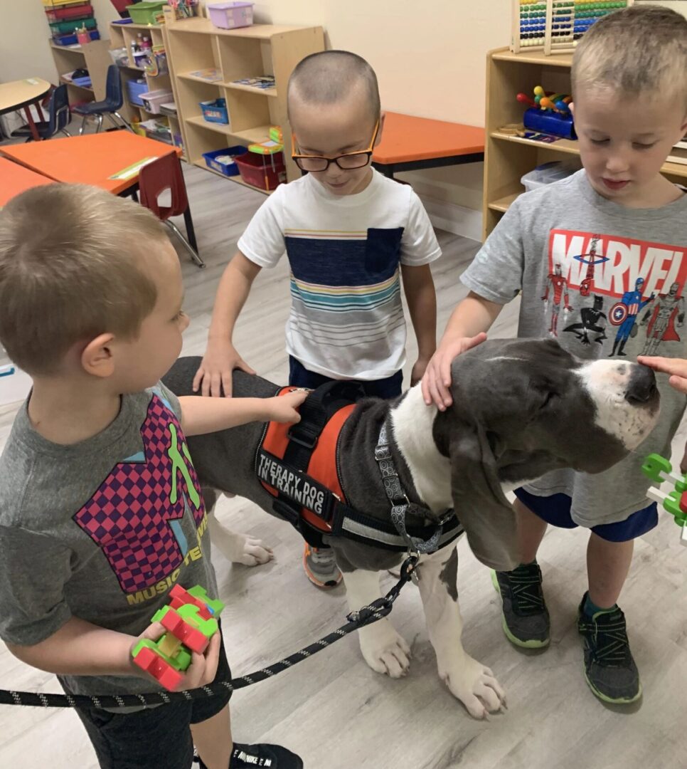 A group of children standing around a dog.