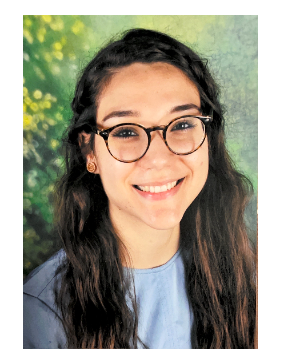 A woman with glasses smiling for the camera.