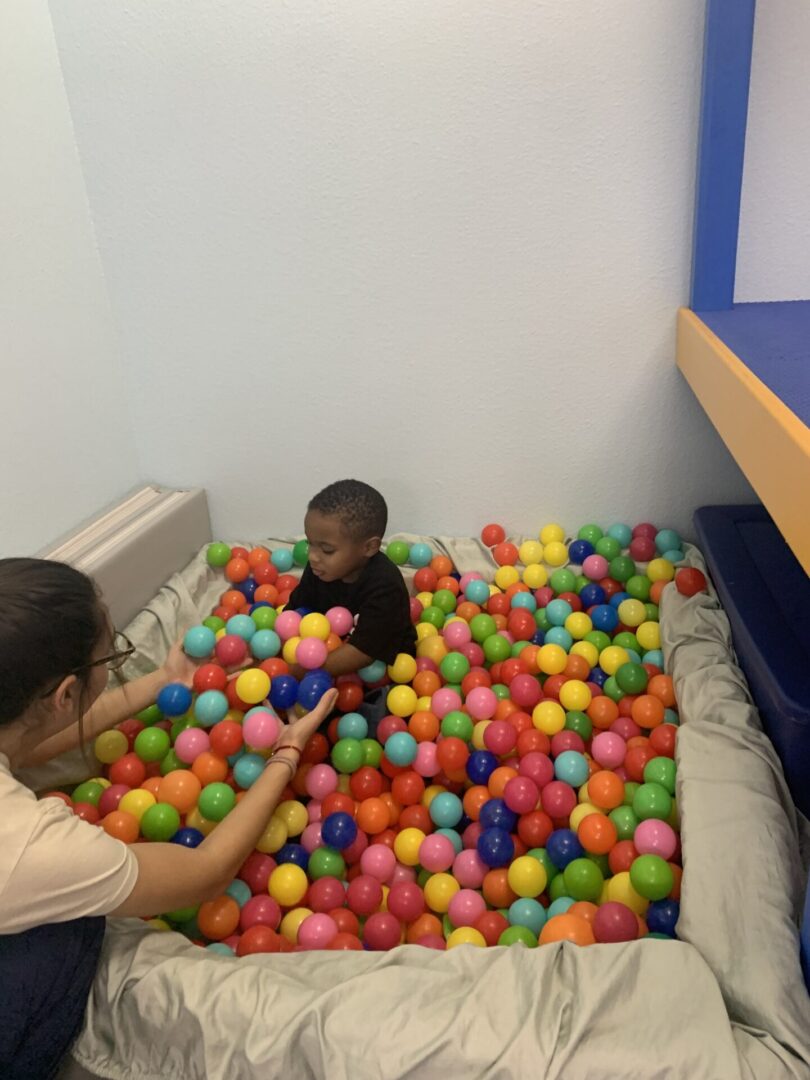 A woman and child playing with balls in a room.